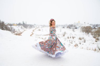 Güzel Rus kızı, ulusal bir kış elbisesi içinde.