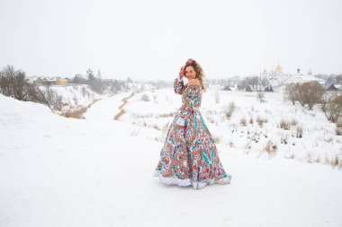 Güzel Rus kızı, ulusal bir kış elbisesi içinde.