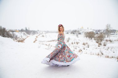 Güzel Rus kızı, ulusal bir kış elbisesi içinde.