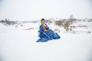Güzel Rus kızı, ulusal bir kış elbisesi içinde.