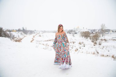 Güzel Rus kızı, ulusal bir kış elbisesi içinde.