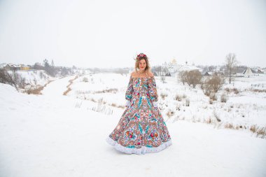 Güzel Rus kızı, ulusal bir kış elbisesi içinde.