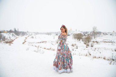 Güzel Rus kızı, ulusal bir kış elbisesi içinde.