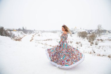 Güzel Rus kızı, ulusal bir kış elbisesi içinde.