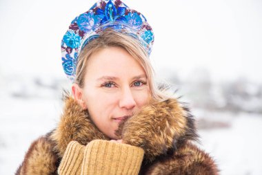 Güzel Rus kızı, ulusal bir kış elbisesi içinde.