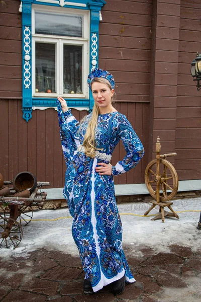 Russian girl in Russian national costumesof winter in a village