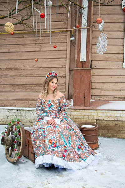 Russian girl in Russian national costumesof winter in a village