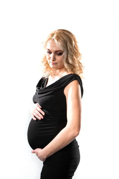Ung vacker gravid kvinna står på rosa bakgrund — Stockfoto