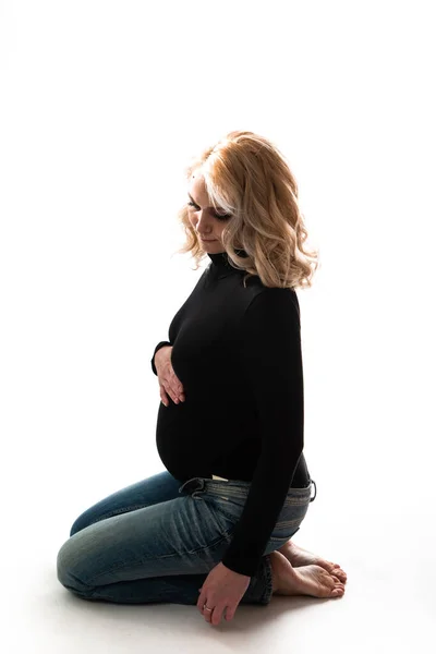 Ung vacker gravid kvinna står på rosa bakgrund — Stockfoto