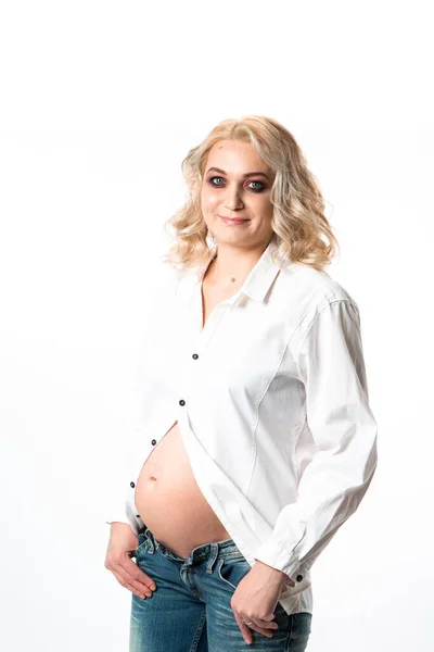 Ung vacker gravid kvinna står på rosa bakgrund — Stockfoto