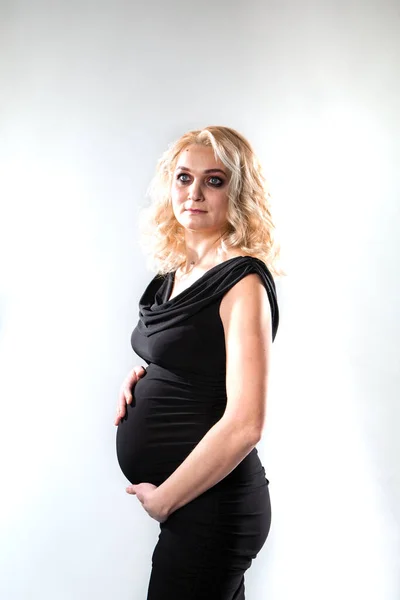 분홍색 배경 위에서 있는 아름답고 임신 한 젊은 여자 — 스톡 사진