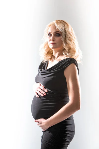 Ung vacker gravid kvinna står på rosa bakgrund — Stockfoto