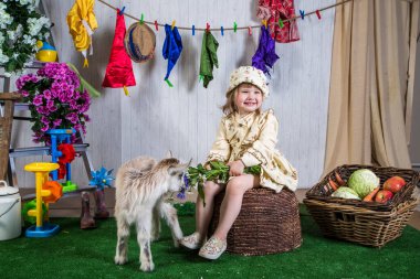 Çiftlik arazisinde keçilerle oynayan küçük kız çocukları