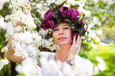 Kiraz çiçeklerinin bahçesindeki güzel genç bayan.