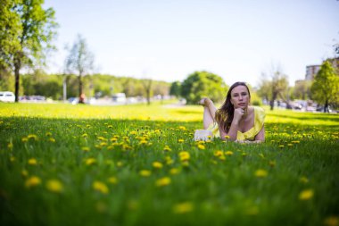 Çiçek tarlasında yatan güzel genç bayan