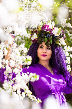 Kiraz çiçeklerinin bahçesindeki güzel genç bayan.