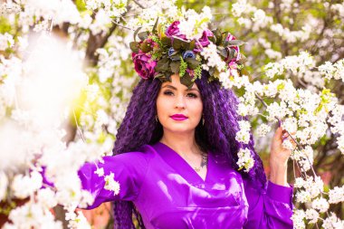 Kiraz çiçeklerinin bahçesindeki güzel genç bayan.