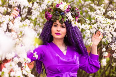 Kiraz çiçeklerinin bahçesindeki güzel genç bayan.