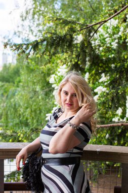 Çiçek bahçesindeki leylak kokusunun tadını çıkaran güzel genç bir kadın.