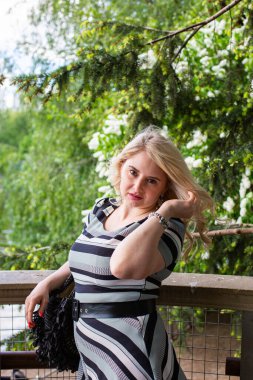 Çiçek bahçesindeki leylak kokusunun tadını çıkaran güzel genç bir kadın.