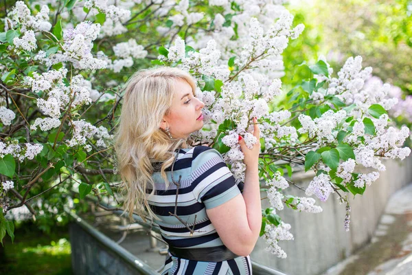Piękna młoda kobieta ciesząca się zapachem lilii w kwitnącym ogrodzie — Zdjęcie stockowe