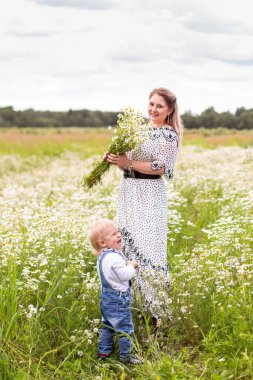 Genç anne ve küçük tatlı oğlu bir tarlada yürüyorlar.