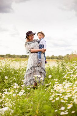 Genç anne ve küçük tatlı oğlu bir tarlada yürüyorlar.