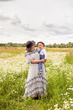 Genç anne ve küçük tatlı oğlu bir tarlada yürüyorlar.
