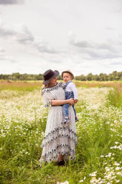 Genç anne ve küçük tatlı oğlu bir tarlada yürüyorlar.