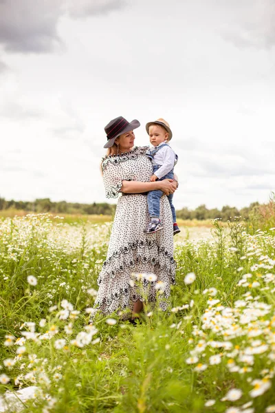 Молодая мать и ее милый маленький сын, идущие в поле Стоковое Фото