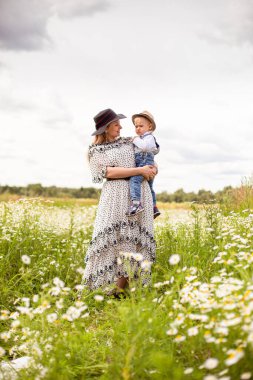 Genç anne ve küçük tatlı oğlu bir tarlada yürüyorlar.
