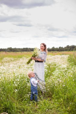 Genç anne ve küçük tatlı oğlu bir tarlada yürüyorlar.