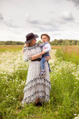 Genç anne ve küçük tatlı oğlu bir tarlada yürüyorlar.