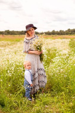Genç anne ve küçük tatlı oğlu bir tarlada yürüyorlar.