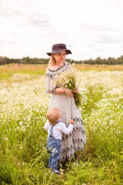 Genç anne ve küçük tatlı oğlu bir tarlada yürüyorlar.