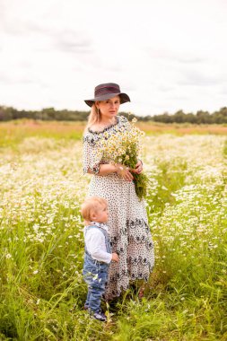 Genç anne ve küçük tatlı oğlu bir tarlada yürüyorlar.