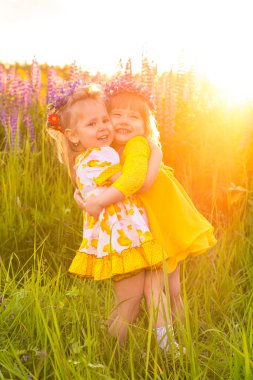 Gün batımında güneşin altında çiçek açan bir tarlada bir kızın portresi.