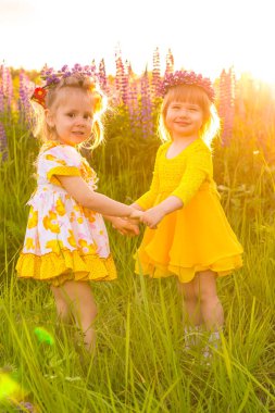 Gün batımında güneşin altında çiçek açan bir tarlada bir kızın portresi.