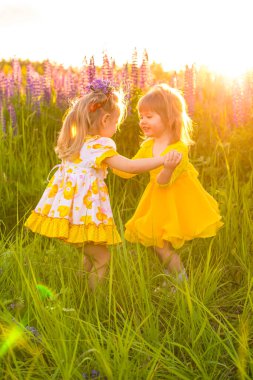 Gün batımında güneşin altında çiçek açan bir tarlada bir kızın portresi.