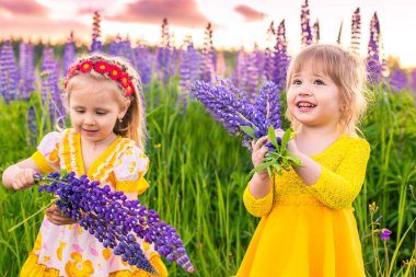 Gün batımında güneşin altında çiçek açan bir tarlada bir kızın portresi.