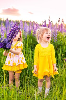 Gün batımında güneşin altında çiçek açan bir tarlada bir kızın portresi.