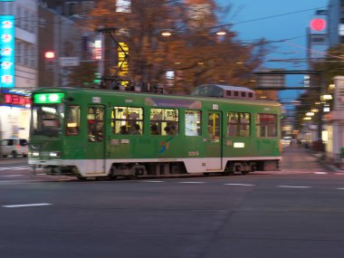 Hokkaido, Japonya-8 Kasım 2020: Gece Sapporo şehrinde Susukino kavşağında bir tramvayın dönmesi