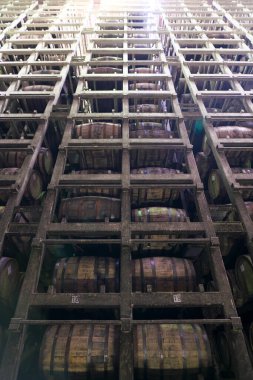 Shizuoka,Japan-Ocotber 6, 2018: Neatly stacked whisky barrels or casks in a giant cellar clipart