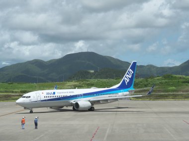 Okinawa, Japonya - 15 Temmuz 2021: Japonya 'nın Okinawa kentindeki Ishigaki havaalanından kalkan uçak için yer bakımı personeli ve tamirci el sallaması
