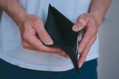 Boş bir cüzdan açan adam, parasızlık, mali sorunlar, borç ve yoksulluğu temsil ediyor.