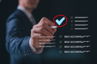İşadamı dijital kontrol listesi raporunda kalem işaretlemesi kullanıyor. Tik kutucuğu araştırması, çevrimiçi onaylı kağıtsız kalite güvencesi ve ERP yönetimi için sanal belgeye işaret işareti imzalayın