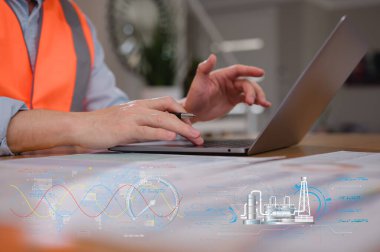 Güvenlik yeleği giyen bir mühendis bilgisayarında yazarak ai teknolojisi diyagramı üzerinde çalışıyor. İş süreçleri ve verilerin dijital dönüşüm teknolojisi stratejisinde DevOps mühendisi