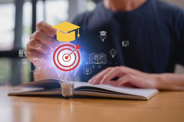 Eğitim araştırma ve öğrenme kavramında ampullü ve simgeli kalem ve açık kitap kullanan bir adam.