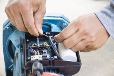 Elektrik motoru ve ekipman çalışan erkeğin çimento zemin zemin üzerine onarın. Arka plan motor veya ekipman. Yakın çekim