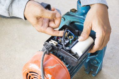 Elektrik motoru ve ekipman çalışan erkeğin çimento zemin zemin üzerine onarın. Arka plan motor veya ekipman. Yakınlaştır